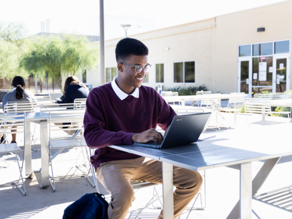 Student working on laptop outdoors